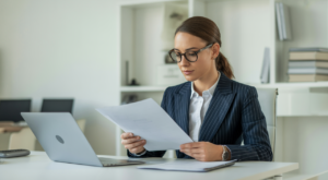 Professional SaaS contracts lawyer reviewing legal documents with laptop in modern office